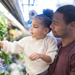 Father with young daughter shopping for groceries